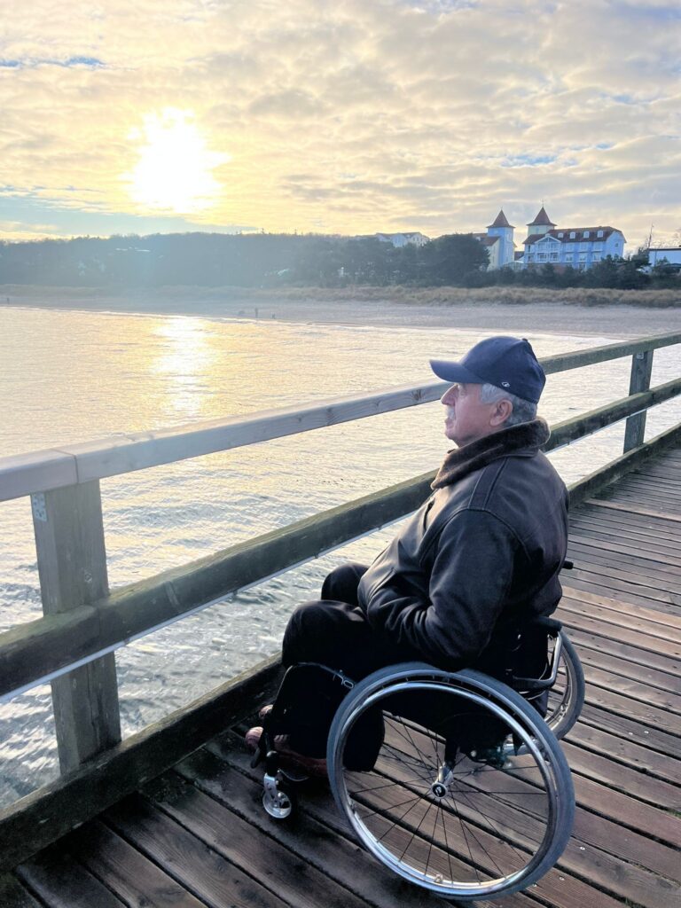 Wolfgang Steffan im Rollstuhl auf der Seebrücke bei Sonnenaufgang